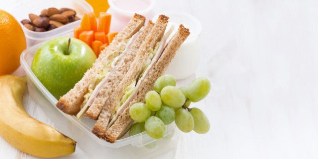 school lunch with sandwiches and fruit on white background, close-up