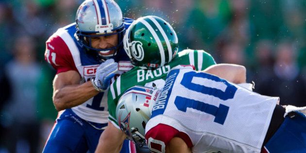 REGINA, SK - SEPTEMBER 27: Rob Bagg #6 of the Saskatchewan Roughriders takes a big hit from Chip Cox #11 and Marc-Olivier Brouillette #10 of the Montreal Alouettes in the game between the Montreal Alouettes and Saskatchewan Roughriders in week 14 of the 2015 CFL season at Mosaic Stadium on September 27, 2015 in Regina, Saskatchewan, Canada. (Photo by Brent Just/Getty Images)