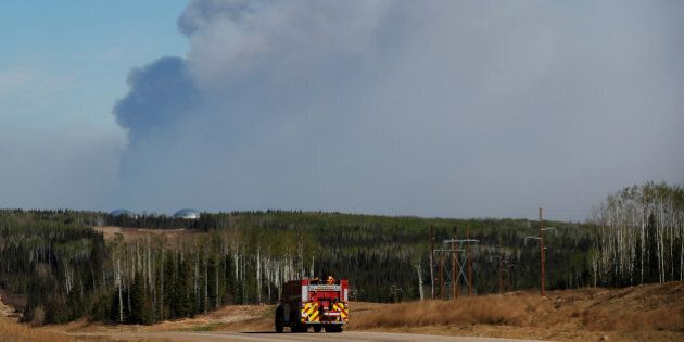 A fire truck drives down a highway in front of the Fort McMurray wildfires in Kinosis, Alberta, Canada, May 6, 2016. REUTERS/Mark Blinch TPX IMAGES OF THE DAY