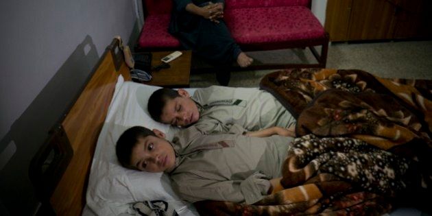 In this photo taken on Thursday, May 5, 2016, Abdul Rasheed, 9, front, and Shoaib Ahmed, 13, lie in a bed at a hospital in Islamabad, Pakistan. The boys are normal active children during the day. But once the sun goes down, they both lapse into a vegetative state â unable to move or talk. Dr. Javed Akram, told The Associated Press on Thursday that he had no idea what was causing the symptoms. (AP Photo/B.K. Bangash)