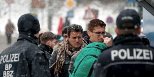 Migrants stand in queue during heavy snowfall before passing Austrian-German border in Wegscheid in Austria, near Passau November 22, 2015. REUTERS/Michael Dalder