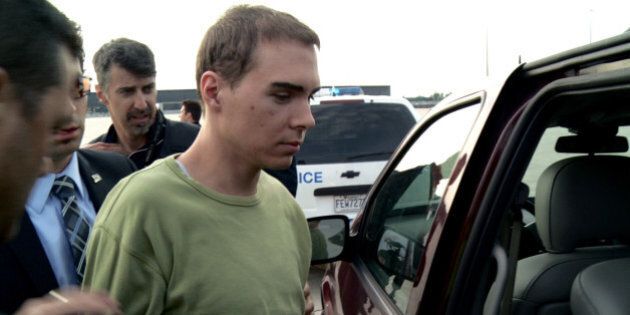 In this photo provided by Montreal Police, Luka Rocco Magnotta is taken by police from a Canadian military plane to a waiting van on Monday, June 18, 2012, in Mirabel, Quebec. Magnotta, the suspect in the killing and dismemberment of a Chinese student, returned to Canada via military transport from Germany, where he was arrested this month. (AP Photo/Montreal Police)