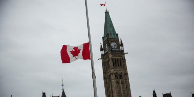 OTTAWA, ON - OCTOBER 23: A flag next to the Canadian Parliament Building is flown at half staff one day after Cpl. Nathan Cirillo of the Canadian Army Reserves was killed while standing guard in front of the National War Memorial by a lone gunman, on October 23, 2014 in Ottawa, Canada. After killing Cirillo the gunman stormed the main parliament building, terrorizing the public and politicians, before he was shot dead. (Photo by Andrew Burton/Getty Images)