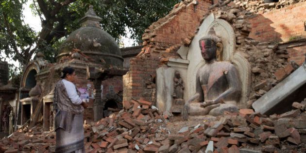A Nepalese woman offers morning prayers at a temple damaged in last Saturday's earthquake in Bhaktapur, Nepal, Saturday, May 2, 2015. A week after the devastating earthquake, life is limping back to normal in Nepal with residents visiting temples on the first Saturday after the quake, a day normally reserved for temple visits. (AP Photo/Bernat Amangue)