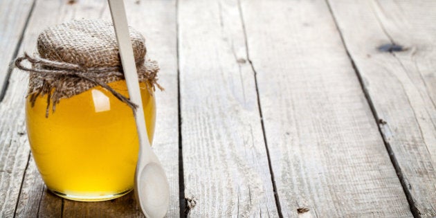 Bowl of honey on wooden table. Symbol of healthy living and natural medicine. Aromatic and tasty.