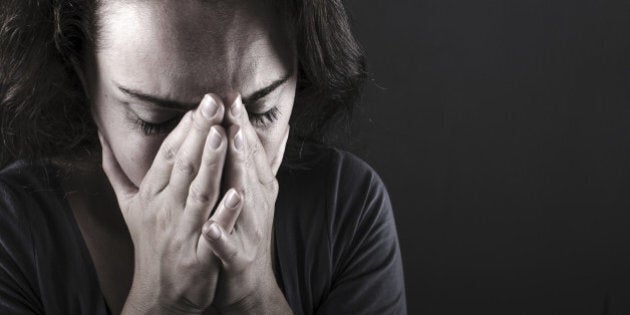 Depressed woman on black background