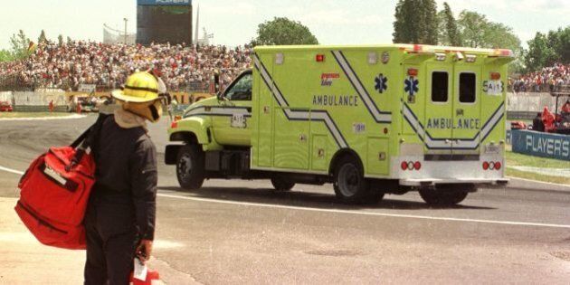 MONTREAL, CANADA - JUNE 15: A fireman watches as an ambulance carrying French Formula One driver Olivier Panis leaves the track at The Grand Prix of Montreal 15 June at the Circuit Gilles The race stopped at 56 laps when Panis crashed his car into a wall on the backside of the track. Panis suffered a fracture right leg. (Photo credit should read ANDRE PICHETTE/AFP/Getty Images)