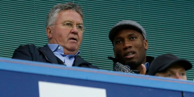 Chelsea's new manager Guus Hiddink, left, sits next to former Chelsea player Didier Drogba before the English Premier League soccer match between Chelsea and Sunderland at Stamford Bridge stadium in London, Saturday, Dec. 19, 2015. Guus Hiddink returned to Chelsea for a second spell as manager on Saturday, hired until the end of the season with the tough task of turning round the struggling Premier League champions following Jose Mourinho's firing. (AP Photo/Matt Dunham)