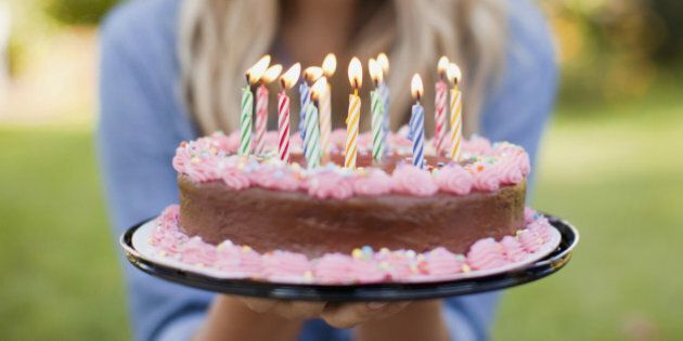 USA, Utah, Provo, Mid-section of young woman holding birthday cake