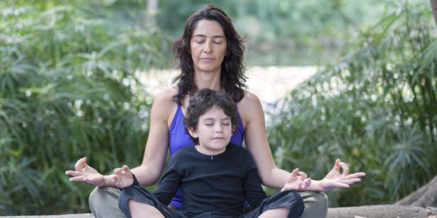 Hispanic mother and son practicing yoga