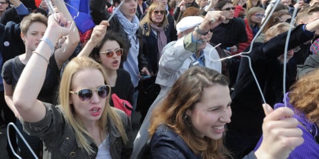 Protesters raise hangers, symbolizing illegal abortion, as they shout slogans demonstrating against a possible tightening of the countrys abortion law, already one of the most restrictive in Europe, in Warsaw, Poland, Sunday, April 3, 2016. Rallies in Warsaw and other cities are being held under the slogan No to the Torture of Women and come as the influential Roman Catholic church launches a campaign for a total ban on abortion, something supported by Prime Minister Beata Szydlo and ruling party leader Jaroslaw Kaczynski. (AP Photo/Alik Keplicz)