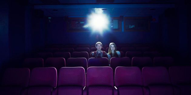 Couple watching a movie in an empty cinema