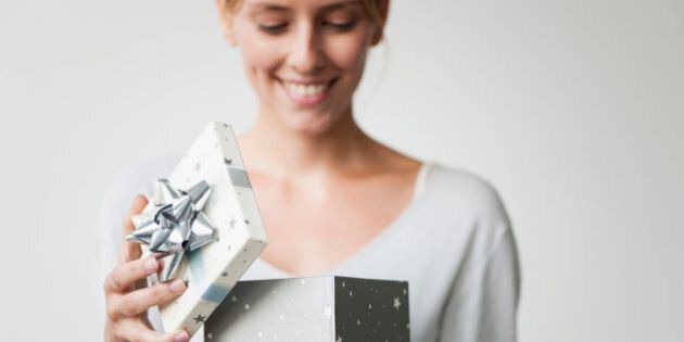 Young woman opening gift box