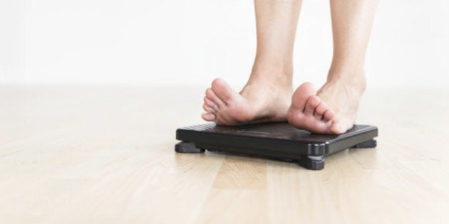 Woman's feet on a scale. Metaphor for diet and healthy living. Close-up with Shallow DOF.