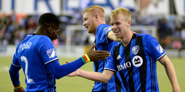 Apr 9, 2016; Montreal, Quebec, CAN; Montreal Impact midfielder Kyle Bekker (18) celebrates with teammates including Montreal Impact defender Ambroise Oyongo (2) after scoring a goal against the Columbus Crew during the second half at Olympic Stadium. Mandatory Credit: Eric Bolte-USA TODAY Sports