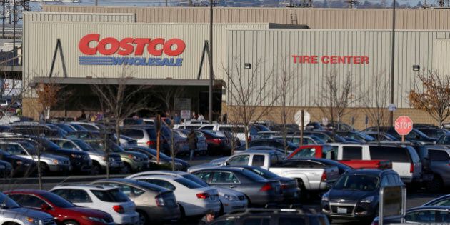 Cars fill the parking lot of a Costco store, Tuesday, Nov. 24, 2015, in Seattle. Health authorities say chicken salad from Costco has been linked to at least one case of E. coli in Washington state. (AP Photo/Ted S. Warren)