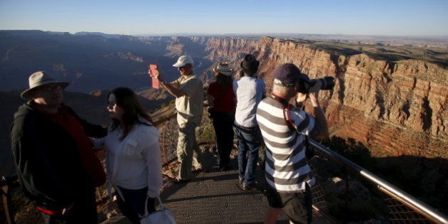 People take photos as the sun sets at the Grand Canyon National Park in northern Arizona, April 13, 2015. Picture taken April 13. REUTERS/Jim Urquhart