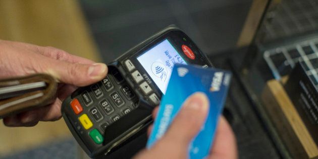 A customer makes a contactless payment with a bank card on an Ingenico Iberia SL payment device in London, U.K., on Friday, May 22, 2015. Credit and debit cards that can be used by tapping the reader are gaining users, and mobile apps are set to further boost the popularity of contactless paying. Photographer: Simon Dawson/Bloomberg via Getty Images