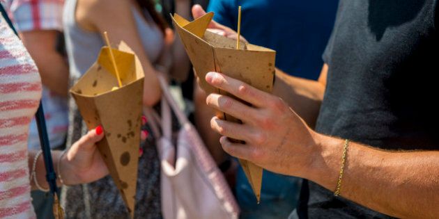 people enjoy street food from paper cones