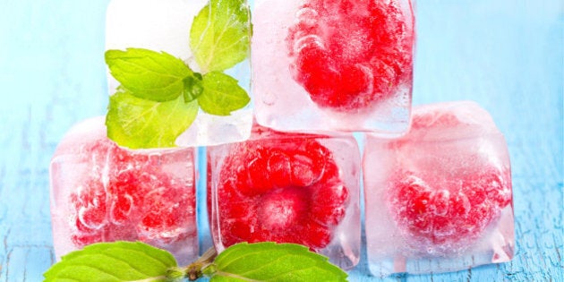 Ice cubes and raspberries with mint leafs