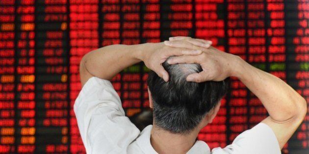 An investor gestures as he checks share prices at a securities firm in Shanghai on August 26, 2015. Shanghai stocks closed down 1.27 percent in volatile trading on August 26, extending days of falls despite a central bank interest rate cut aimed at boosting the flagging economy and slumping shares, dealers said. CHINA OUT AFP PHOTO (Photo credit should read STR/AFP/Getty Images)