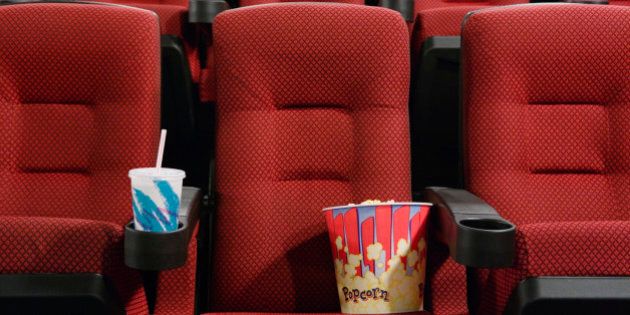 Popcorn and Soft Drink in Empty Seat at the Movie Theater