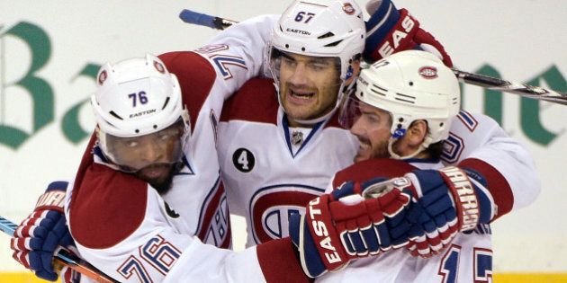 Montreal Canadiens left wing Max Pacioretty,center, is congratulated by defenseman P.K. Subban, left, and center Torrey Mitchell, right, after Pacioretty scored during the first period of Game 4 of a second-round NHL Stanley Cup hockey playoff series against the Tampa Bay Lightning in Tampa, Fla., Thursday, May 7, 2015. (AP Photo/Phelan M. Ebenhack)