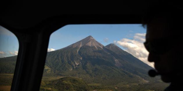 A picture taken through a helicopter window shows an aerial view of the Fuego (L) and the Acatenango volcanoes in the Escuintla departament, 80 km south of Guatemala City on April 7, 2016. / AFP / JOHAN ORDONEZ (Photo credit should read JOHAN ORDONEZ/AFP/Getty Images)