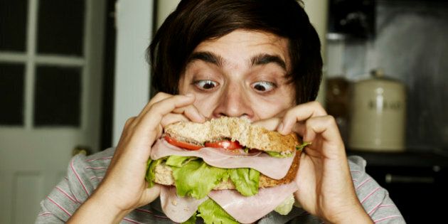 Portrait of man eating sandwich