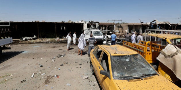 Residents gather at the site of a car bomb attack in Rashidiya, a district north of Baghdad, Iraq July 12, 2016. REUTERS/Ahmed Saad