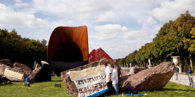 VERSAILLES, FRANCE - SEPTEMBER 21: Employees apply gold leaf to cover the vandelism suffered by 'Dirty Corner' by British-Indian sculptor Anish Kapoor in the garden of Chateau de Versailles on September 21, 2015 in Versailles, France. Following a court order, Anish Kapoor has decided to cover anti semitic graffiti on his controversial sculpture after the piece was vandalized three times since its inauguration. (Photo by Chesnot/Getty Images)