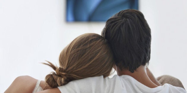 Rearview shot of a young couple cuddling together on the couch