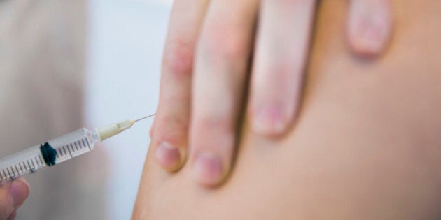 Cropped image of doctor injecting patient in clinic