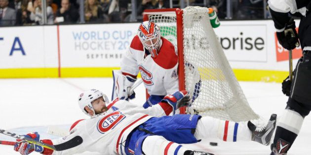 Montreal Canadiens' Andrei Markov, bottom, of Russia, slides in front of goalie Ben Scrivens to stop a shot by Los Angeles Kings' Jeff Carter during the second period of an NHL hockey game Thursday, March 3, 2016, in Los Angeles. (AP Photo/Jae C. Hong)