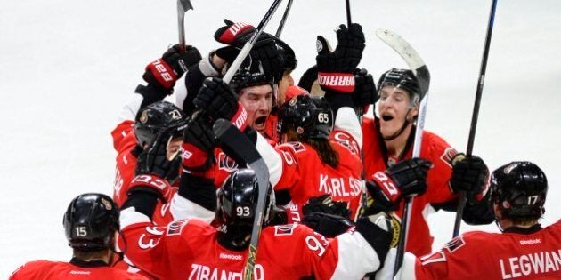 Ottawa Senators' Mark Stone (61) (centre) is surrounded by his teammates after scoring the game winning goal against the Pittsburgh Penguins during overtime NHL action in Ottawa on Tuesday April 7, 2015, in Ottawa. The Senators defeated the Penguins 4-3. THE CANADIAN PRESS/Justin Tang