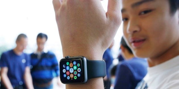 A customer tries on an Apple Watch at an Apple Store in Hong Kong Friday, April 10, 2015. From Beijing to Paris to San Francisco, the Apple Watch made its debut Friday. Customers were invited to try them on in stores and order them online. (AP Photo/Kin Cheung)