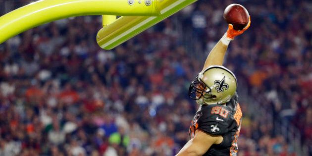 New Orleans Saints' Jimmy Graham leaps to throw the ball over the goal post after scoring a touchdown during the first half of the NFL Football Pro Bowl Sunday, Jan. 25, 2015, in Glendale, Ariz. (AP Photo/Charlie Riedel)
