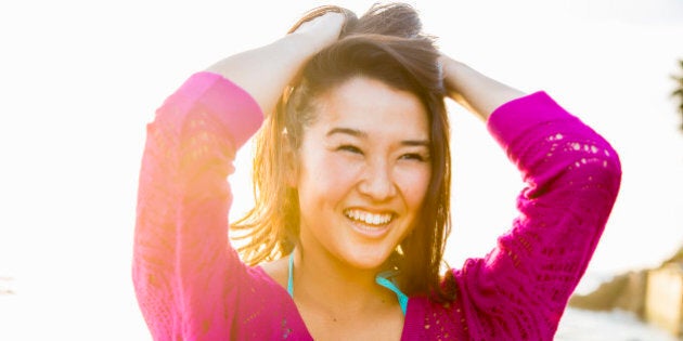 Beautiful woman at beach at sunset laughing