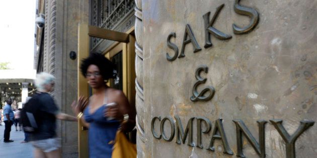 Shoppers use a Fifth Avenue entrance to Saks, in New York, Monday, July 29, 2013. Saks Inc. agreed to sell itself to Hudson's Bay Co., the Canadian parent of upscale retailer Lord & Taylor, for about $2.4 billion in a deal that will bring luxury to more North American locales. (AP Photo/Richard Drew)