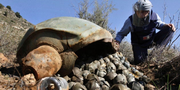 ** FILE ** In this Nov. 9, 2006 file picture, Mines Advisory Group (MAG) Technical Field Manager Nick Guest inspects a Cluster Bomb Unit in the southern village of Ouazaiyeh, Lebanon. International diplomats from more than 100 nations reached agreement on a treaty that would ban current designs of cluster bombs and require the destruction of stockpiles within eight years. The breakthrough Wednesday May 28, 2008 capped more than a year of negotiations that began in Norway and concluded over the past 10 days in Dublin, but Israel, U.S. Russia, China, India and Pakistan did not participate in the treaty. (AP Photo/Mohammed Zaatari)