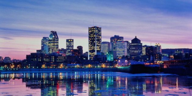 Canada,Quebec,Montreal view of city skyline reflected in river at dusk