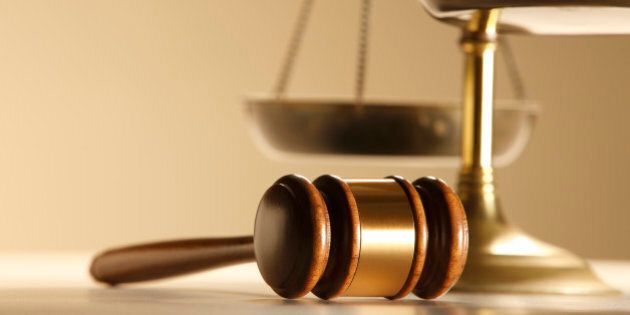 A gavel in front of a justice scale.