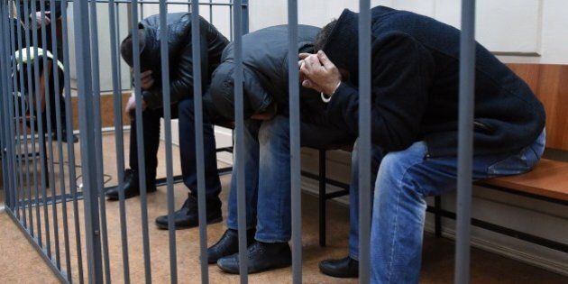 Three unidentified suspects detained over the killing of Russian opposition activist Boris Nemtsov hide their faces inside the defendants' cage at the Basmanny district court in Moscow on March 8, 2015. Five suspects accused of involvement in the killing of Russian opposition activist Boris Nemtsov appeared in court to determine whether they will be officially placed in detention. Two Chechens, Zaur Dadayev and Anzor Gubashev were officially accused of 'the murder of Boris Nemtsov and three others are still suspects,' Anna Fadeyeva, spokeswoman for the court in central Moscow told the RIA Novosti news agency. AFP PHOTO / DMITRY SEREBRYAKOV (Photo credit should read DMITRY SEREBRYAKOV/AFP/Getty Images)