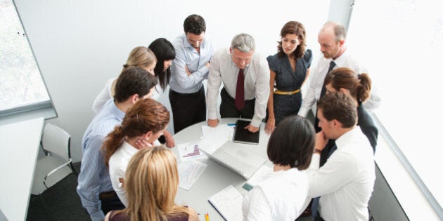 Businesspeople gathering around office table