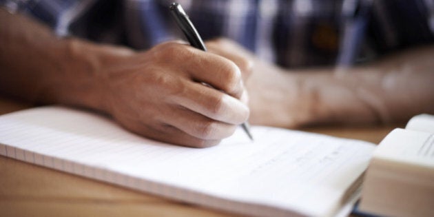 Closeup shot of a young student writing on a note pad