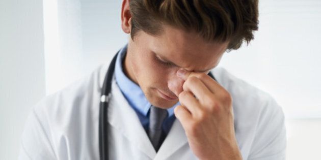 Shot of an upset young doctor taking a moment to himself