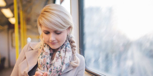 Woman using smart phone in metro.