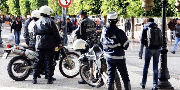 Police officers patrol in the main avenue of Tunis, Thursday, Nov. 26, 2015. Tunisian authorities have identified a suicide bomber who targeted presidential guards in a deadly attack, saying he was a 27-year-old local street vendor. The Islamic State group claimed responsibility for Tuesday's attack on a bus in central Tunis, which left 12 dead plus the attacker. (AP Photo/Hassene Dridi)