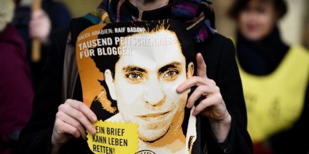 An Amnesty International activist holds a picture of Saudi blogger Raif Badawi during a protest against his flogging punishment on January 29, 2015 in front of Saudi Arabia's embassy to Germany in Berlin. The 30-year-old Saudi has been sentenced to 1,000 lashes for insulting Islam and is serving a 10-year jail term - a case which has drawn widespread international criticism. AFP PHOTO / TOBIAS SCHWARZ (Photo credit should read TOBIAS SCHWARZ/AFP/Getty Images)