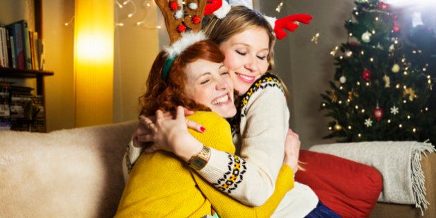 Female friends embrace at Christmas.